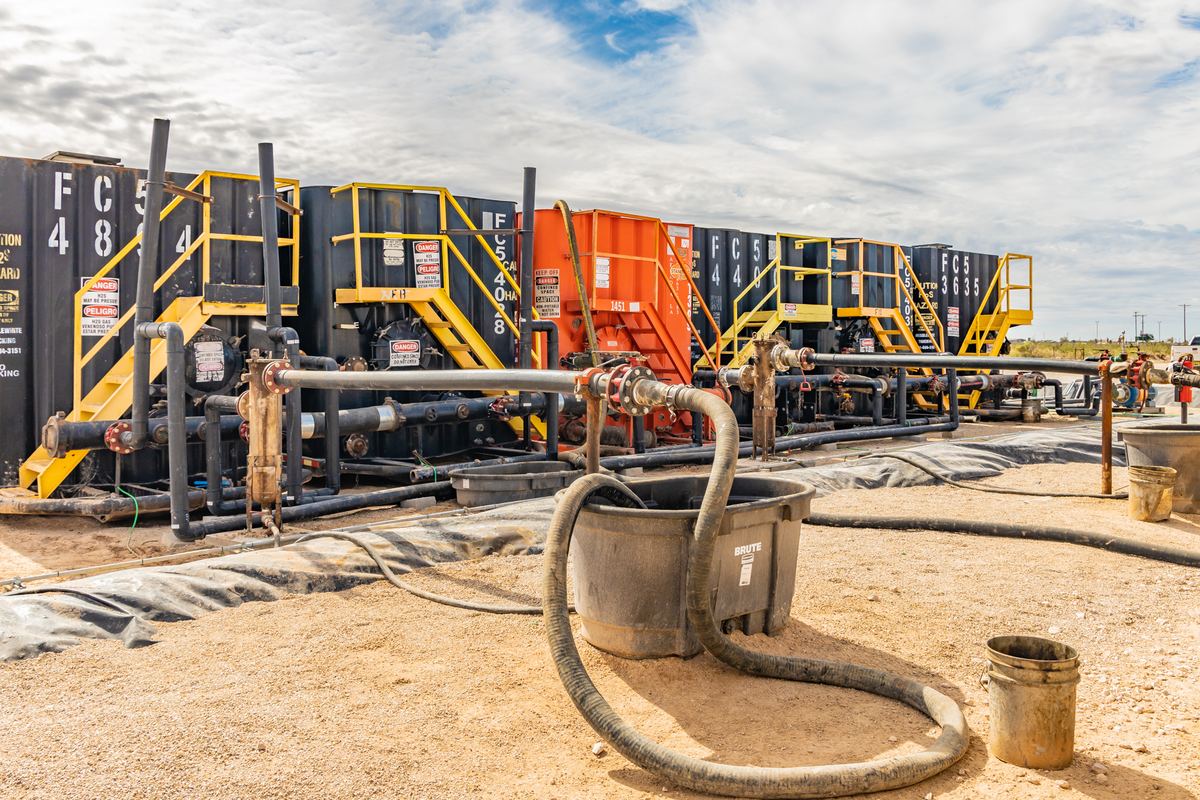 Row of tanks with yellow stairways, H2S warning signs and filtration piping