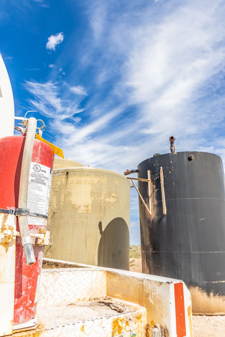 Storage tanks with a fire extinguisher in the foreground