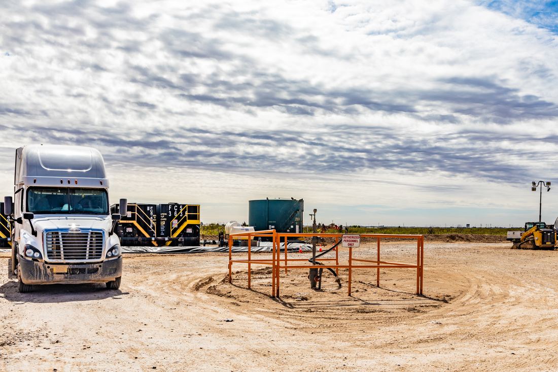 A tractor-trailer on the open caliche pad